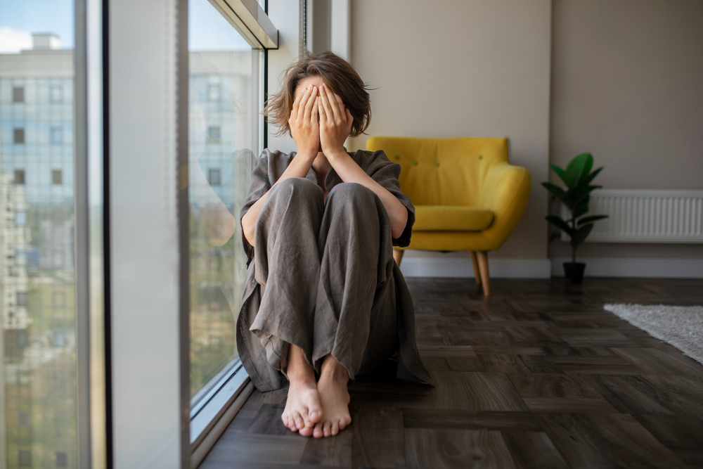 Woman with trauma sitting on floor front view