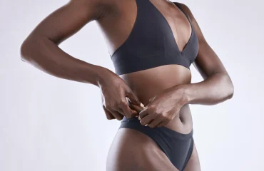 Studio shot of a woman pulling the skin on her outer waist