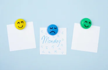 Top view of sticky notes with sad face for blue monday and smiley faces