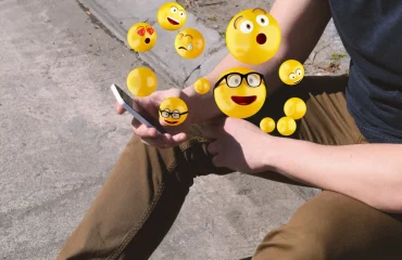 Man using smartphone sending emojis