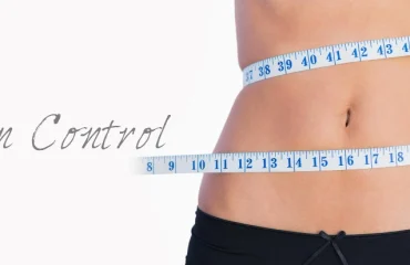 Fit belly surrounded by measuring tape on white background