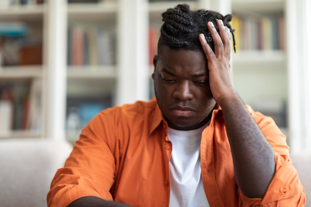 OCD black guy sitting alone on couch at home