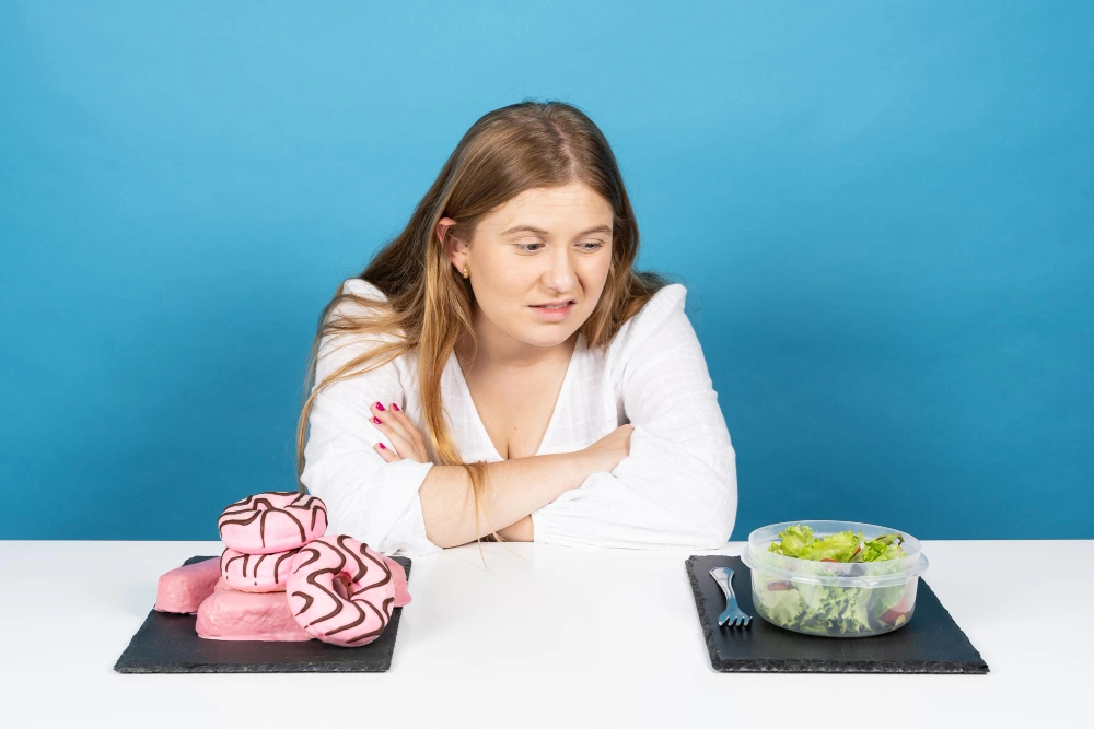 Woman looking with frustrated face to salad