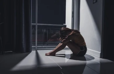 PTSD young woman sitting alone on the floor in the living room