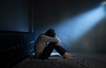 Sad man with Depressive on the bed in the dark room