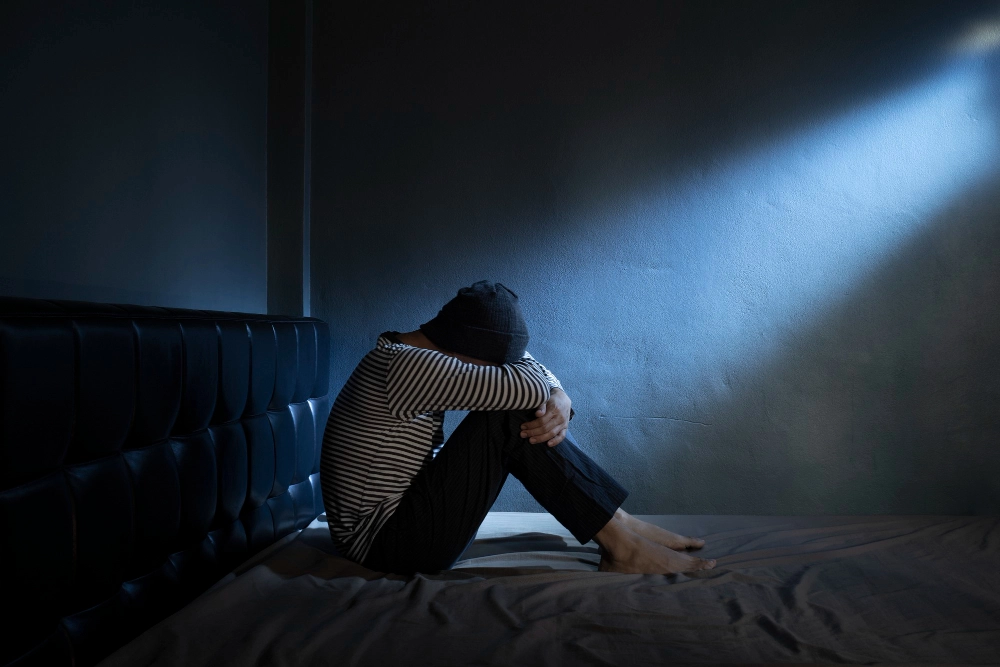 Sad man with Depressive on the bed in the dark room