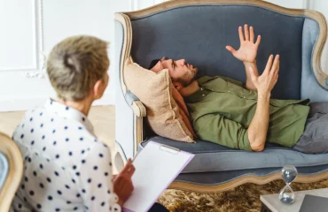 Side view of a young Caucasian man on the couch gesticulating during the therapy session