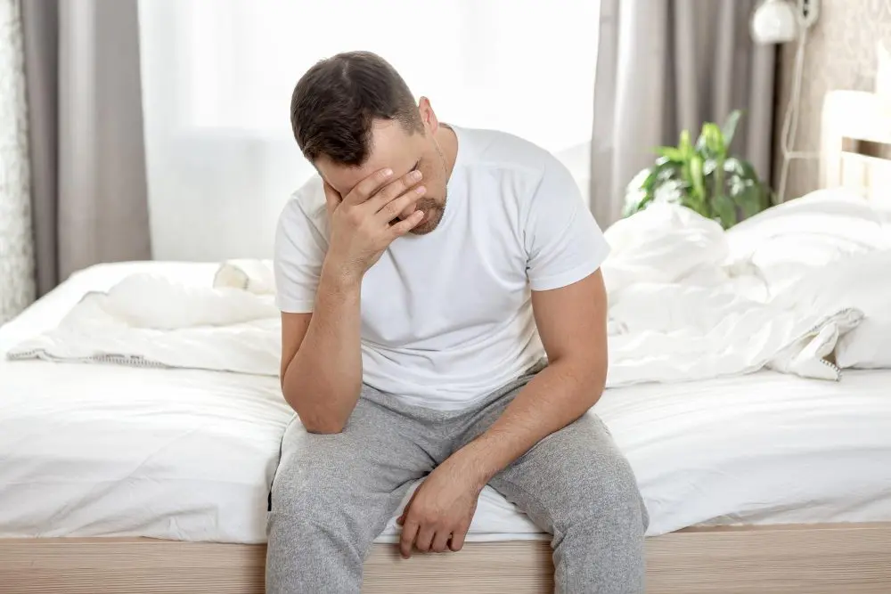 frustrated-man-sits-bed-his-bedroom