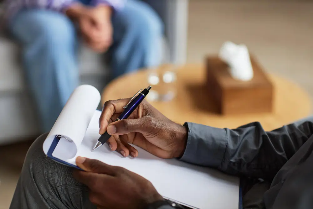 Therapist taking notes during a counseling session